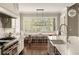 Spacious kitchen featuring a dining area with large windows, custom cabinetry, and a farmhouse sink at 670 Trinity Pl, Suwanee, GA 30024