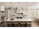 Gourmet kitchen with a large center island, white cabinetry, marble countertops, and pendant lighting at 670 Trinity Pl, Suwanee, GA 30024