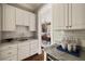 Charming kitchen featuring marble countertops, stainless steel sink, and modern white cabinets at 670 Trinity Pl, Suwanee, GA 30024