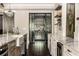 Open-concept kitchen with view into the custom wine cellar, marble countertops, and designer finishes at 670 Trinity Pl, Suwanee, GA 30024