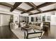 Open concept living room with wood beam ceiling, comfortable seating and an open kitchen with bar area at 670 Trinity Pl, Suwanee, GA 30024