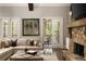 Cozy living room with stone fireplace, comfortable sofa, and access to the screened porch at 670 Trinity Pl, Suwanee, GA 30024