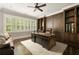 Beautiful home office featuring hardwood floors, custom cabinets, built in shelving, and ample natural light at 670 Trinity Pl, Suwanee, GA 30024
