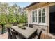 Outdoor dining area on a deck with comfortable seating and a view of the lush landscape at 670 Trinity Pl, Suwanee, GA 30024