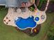 Aerial view of a custom pool with spa, tanning ledge, lush landscaping, and outdoor seating at 670 Trinity Pl, Suwanee, GA 30024