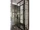 Modern wine cellar featuring steel and glass door, wine racks and elegant marble flooring at 670 Trinity Pl, Suwanee, GA 30024