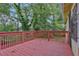 A spacious back deck with red painted wood overlooks a yard with trees at 1162 Sims St, Atlanta, GA 30310