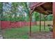 View from beneath the back deck with a yard, bordered by a vibrant red fence at 1162 Sims St, Atlanta, GA 30310