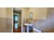A bathroom with tan tiles, a sink with a pedestal, and a doorway at 1162 Sims St, Atlanta, GA 30310