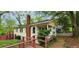 Charming home featuring a brick chimney, covered porch, and lush green surroundings at 1162 Sims St, Atlanta, GA 30310