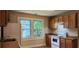 This kitchen features wood cabinets, an oven, a white fridge, and two windows at 1162 Sims St, Atlanta, GA 30310