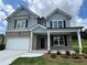 Charming two-story home featuring a brick and siding exterior with black shutters, a covered entrance and a two-car garage at 3064 Steinbeck Way, Atlanta, GA 30344