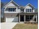 Charming two-story home features a brick facade, gray siding, an attached two-car garage, and manicured lawn at 3064 Steinbeck Way, Atlanta, GA 30344
