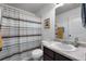 Neutral bathroom with a sink vanity, toilet, and a shower with a striped curtain at 596 Deadwood Trl, Locust Grove, GA 30248