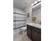 Neutral bathroom with a sink vanity, toilet, and a shower with a striped curtain at 596 Deadwood Trl, Locust Grove, GA 30248