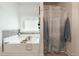 Bathroom featuring a soaking tub with a window and a shower with a stylish curtain at 596 Deadwood Trl, Locust Grove, GA 30248