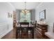 Formal dining room featuring wainscoting, a chandelier, and a large window for natural light at 596 Deadwood Trl, Locust Grove, GA 30248