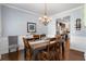 Elegant dining room with wainscoting, chandelier, and a view into the kitchen, perfect for entertaining at 596 Deadwood Trl, Locust Grove, GA 30248