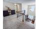 Bright entryway featuring carpeted stairs, a dark wood railing, and a view of the front door at 596 Deadwood Trl, Locust Grove, GA 30248