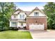 Well-maintained home with brick accents, a two-car garage, inviting front porch, and manicured landscaping at 596 Deadwood Trl, Locust Grove, GA 30248