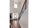 Bright foyer with hardwood floors, staircase with elegant railings, and a decorative wreath on the front door at 596 Deadwood Trl, Locust Grove, GA 30248