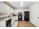 Traditional kitchen with white cabinets, granite counters, and black appliances at 115 Jamie Dr, Hiram, GA 30141