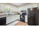 Traditional kitchen with white cabinets, granite counters, and black appliances at 115 Jamie Dr, Hiram, GA 30141