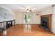 Open living room with hardwood floors, fireplace, ceiling fan, and staircase at 115 Jamie Dr, Hiram, GA 30141