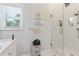 Modern bathroom with a glass-enclosed shower, marble walls, and storage shelves at 1598 Jonesboro Se Rd, Atlanta, GA 30315
