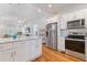 Bright, modern kitchen with white cabinets, stainless steel appliances, marble countertops, and hardwood floors at 1598 Jonesboro Se Rd, Atlanta, GA 30315