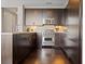 Modern kitchen with stainless steel appliances, dark wood cabinets, granite countertops, and stylish tile backsplash at 3630 Peachtree Rd # 1909, Atlanta, GA 30326