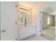 Bathroom vanity with white cabinets, a large mirror, and an entrance to the bedroom at 7325 Thoreau Cir, Atlanta, GA 30349
