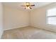 Neutral bedroom with a ceiling fan and a window letting in natural light at 7325 Thoreau Cir, Atlanta, GA 30349
