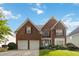 Charming two-story brick home boasts a well-manicured lawn, attached two car garage, and inviting curb appeal at 7325 Thoreau Cir, Atlanta, GA 30349