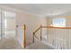 Well-lit hallway with white railings and a decorative hanging lamp near the arched window at 7325 Thoreau Cir, Atlanta, GA 30349