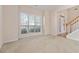 Carpeted room featuring a large window with natural light and access to a foyer at 7325 Thoreau Cir, Atlanta, GA 30349