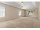 Spacious main bedroom with large windows, a ceiling fan, and light beige walls at 7325 Thoreau Cir, Atlanta, GA 30349