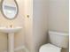 Traditional powder room with pedestal sink, oval mirror, and standard toilet at 7325 Thoreau Cir, Atlanta, GA 30349