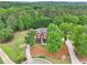 Expansive aerial view of a home surrounded by lush greenery and mature trees, offering privacy at 1424 Brighton, Loganville, GA 30052