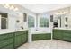 Spacious bathroom with double vanities, a large soaking tub, and stylish green cabinetry at 1424 Brighton, Loganville, GA 30052