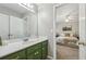 Bathroom featuring green cabinetry, a white countertop, and a view into an adjacent bedroom, creating an open feel at 1424 Brighton, Loganville, GA 30052