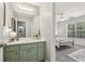 Bright bathroom with green vanity, modern fixtures, and doorway view to a sunlit bedroom, offering style and convenience at 1424 Brighton, Loganville, GA 30052