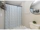 Neutral bathroom featuring patterned shower curtain, a round mirror, and minimalist decor for a clean, modern look at 1424 Brighton, Loganville, GA 30052