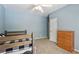 Bedroom with neutral blue walls and a wooden bunk bed with black and white plaid bedding at 1424 Brighton, Loganville, GA 30052