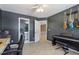Bedroom featuring dark gray walls, a piano, guitars, and neutral carpeting, creating a cozy and artistic space at 1424 Brighton, Loganville, GA 30052