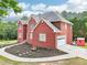 Red brick two-story home featuring a two-car garage and landscaped front yard at 1424 Brighton, Loganville, GA 30052