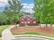 A brick two-story home with a manicured lawn and covered front porch at 1424 Brighton, Loganville, GA 30052