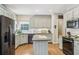 Well-lit kitchen featuring an island, stainless appliances, light countertops and cabinets and hardwood floors at 1424 Brighton, Loganville, GA 30052