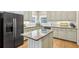 Bright kitchen with a center island, light cabinets, granite countertops, and modern stainless steel appliances at 1424 Brighton, Loganville, GA 30052