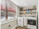 Well-lit laundry room with modern appliances, shelving, and a window at 1424 Brighton, Loganville, GA 30052
